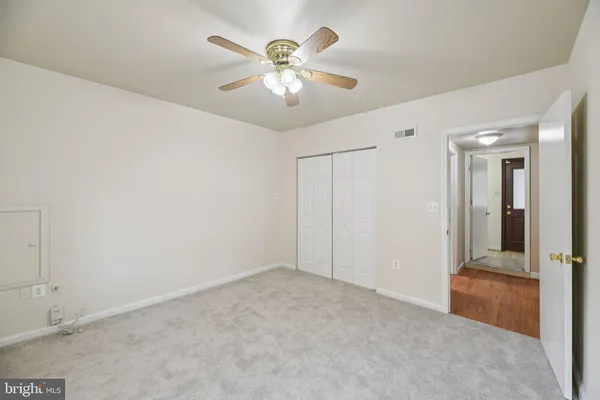 an empty room with fan and entrance