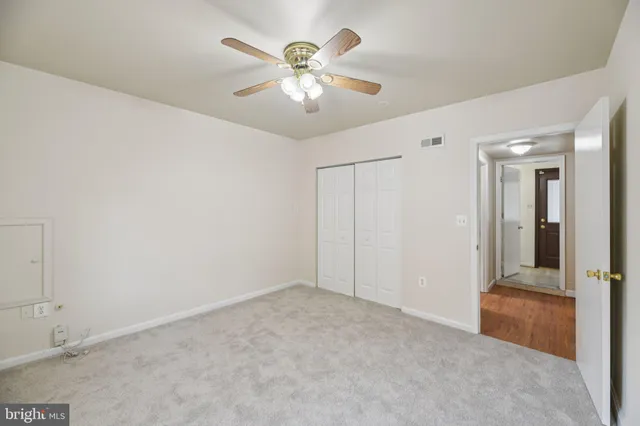 an empty room with fan and entrance