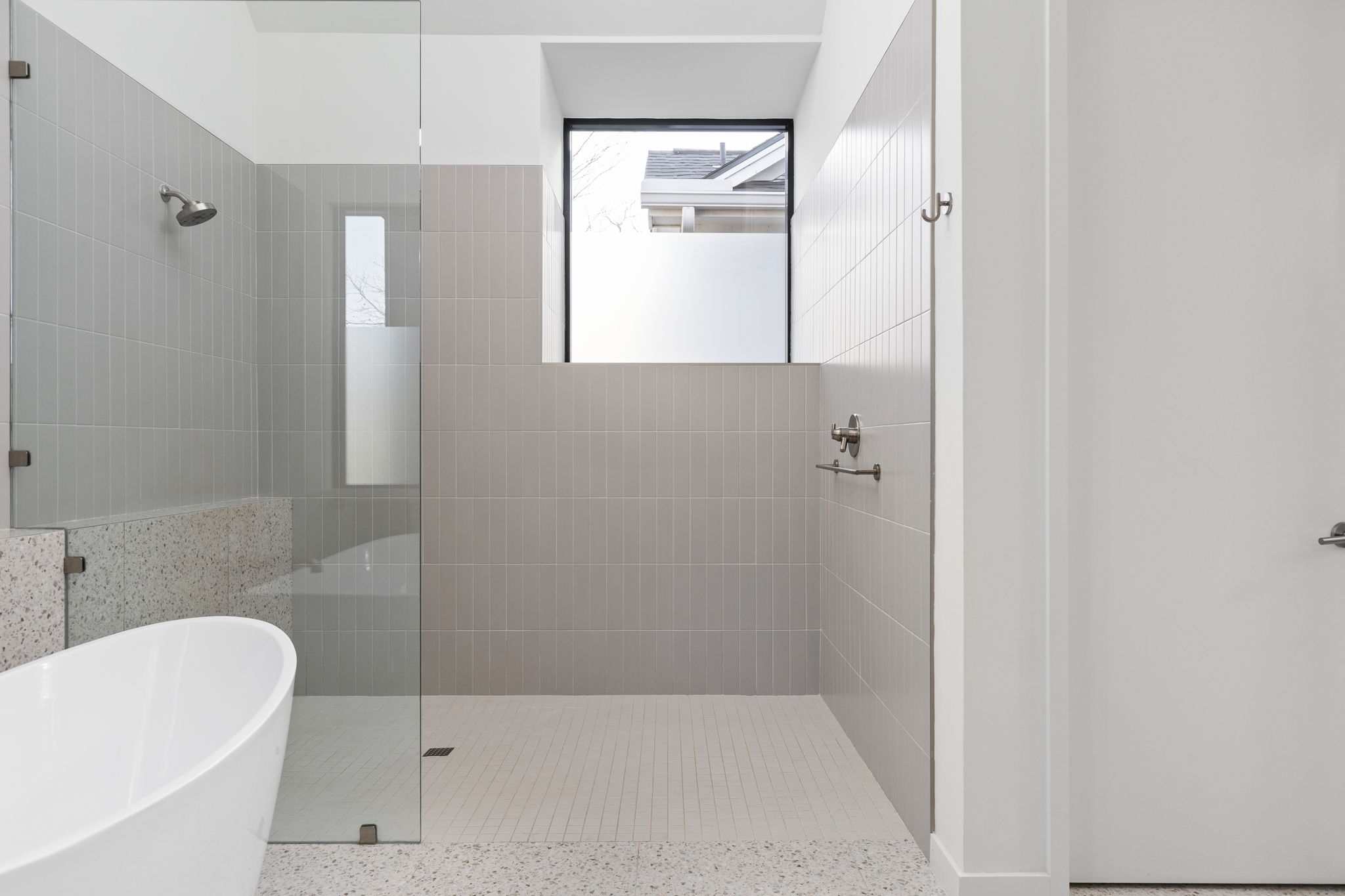 7502 St Louis Street Austin, TX 78757 - Photo 15 of 38 Bathroom featuring a walk in shower and a freestanding bath