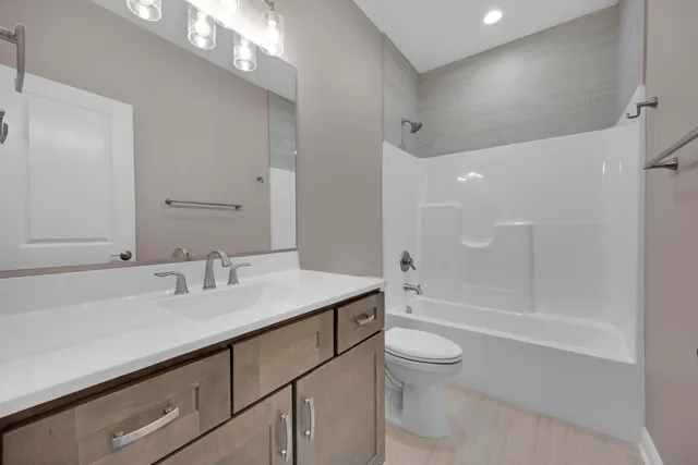a spacious bathroom with a double vanity sink toilet and a mirror