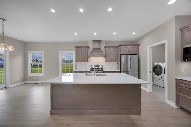 a large kitchen with stainless steel appliances granite countertop a large counter top a stove and a sink