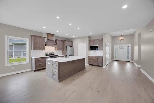 a kitchen with stainless steel appliances kitchen island granite countertop a stove and a sink