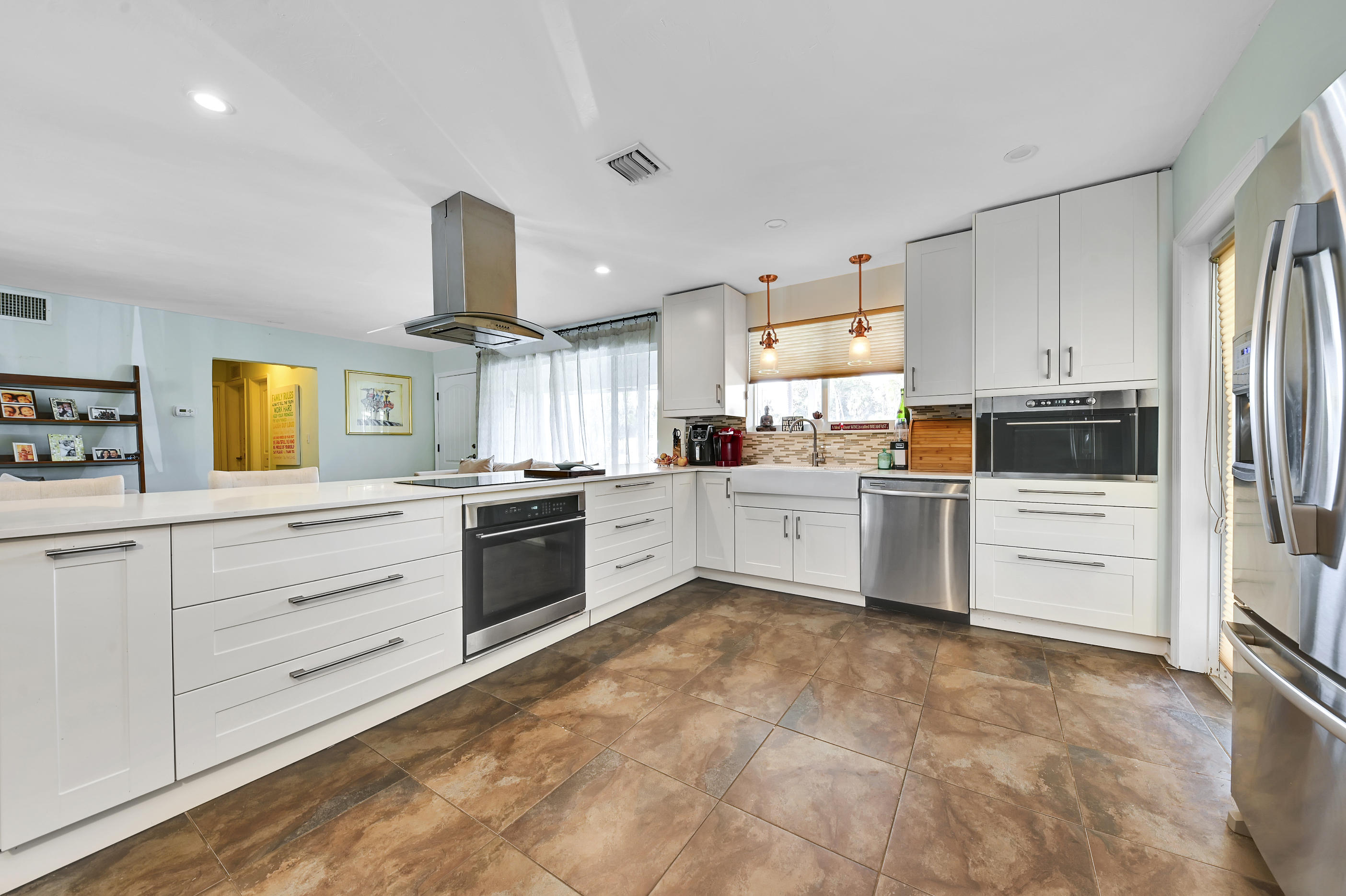 242 Northwest 12th Avenue Boca Raton, FL 33486 - Photo 4 of 13 a kitchen with white cabinets and white appliances
