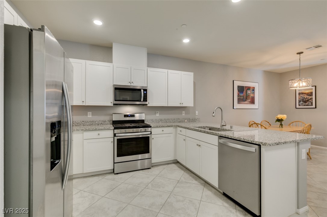 2870 Turnstone Ridge Street Henderson, NV 89044 - Photo 24 of 50 Kitchen featuring stainless steel appliances, a sink, white cabinets, a peninsula, and recessed lighting