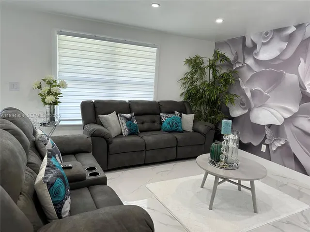 a living room with furniture and a potted plant