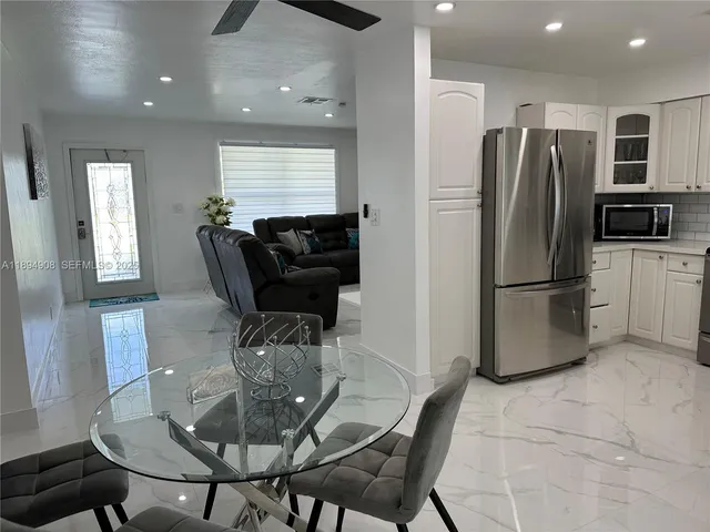 a kitchen with a refrigerator a table and chairs
