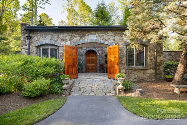 a view of a chairs and table in backyard with a fireplace