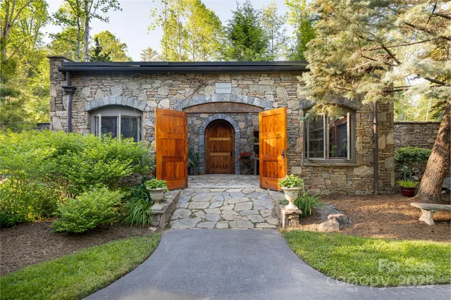 a view of a chairs and table in backyard with a fireplace