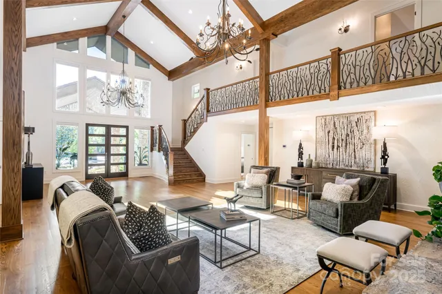 a living room with furniture a chandelier and a large window