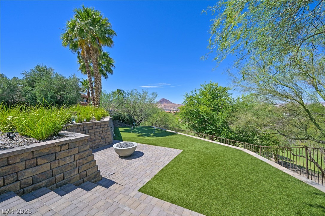 6 Rue Du Ville Henderson, NV 89011 - Photo 80 of 99 Enjoy outdoor living with a private putting green, fire pit, and expansive mountain views.