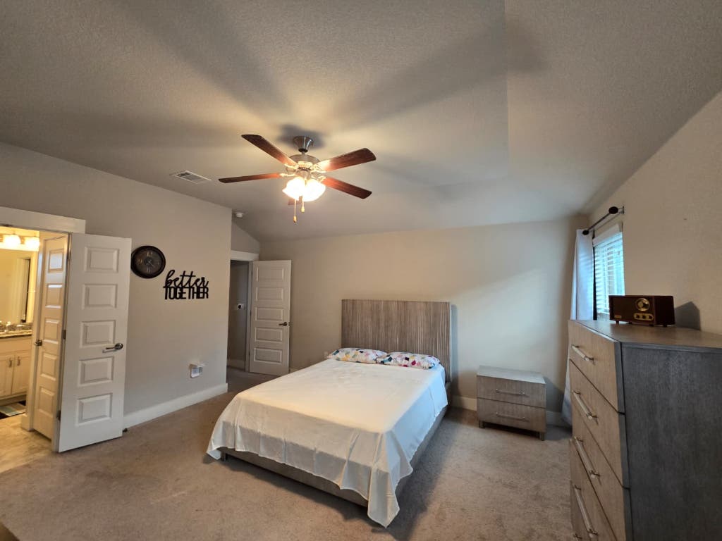9713 McKnight Loop, Unit 34 Austin, TX 78717 - Photo 13 of 17 a bedroom with a bed and a chandelier