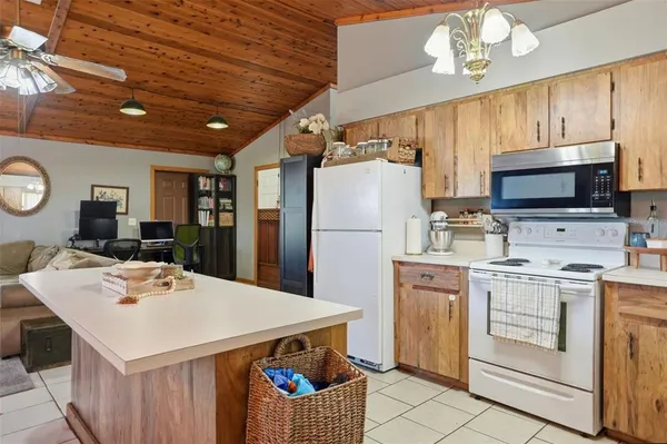 a kitchen that has a lot of white cabinets and stainless steel appliances