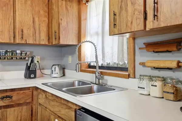 a kitchen with stainless steel appliances granite countertop a sink and a wooden cabinets