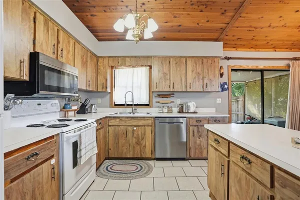 a kitchen with a stove sink and cabinets