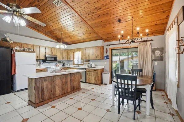 a kitchen with stainless steel appliances a table chairs and a refrigerator