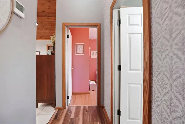 a view of a hallway with wooden floor and closet