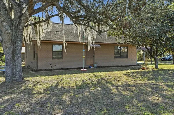 a backyard of house with a tree