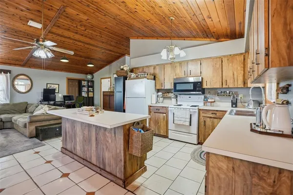 a kitchen that has a lot of white cabinets a sink and a stove