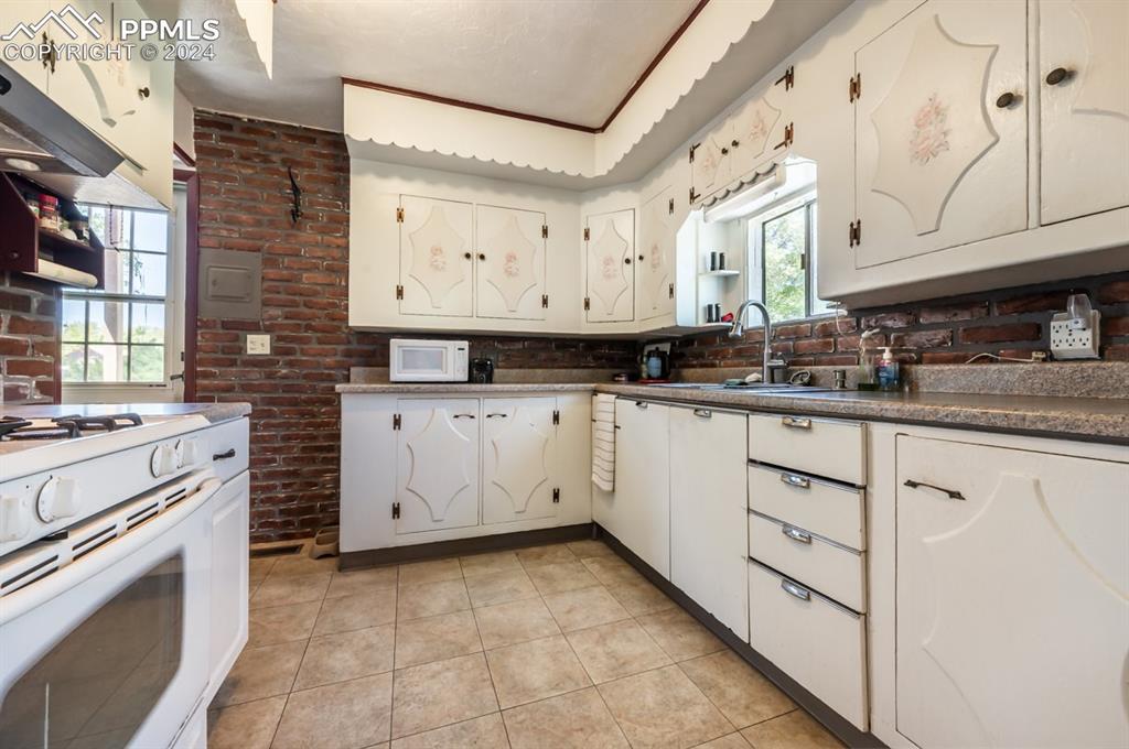 2233 Daniel Road Pueblo, CO 81006 - Photo 12 of 48 a kitchen with white cabinets and white appliances