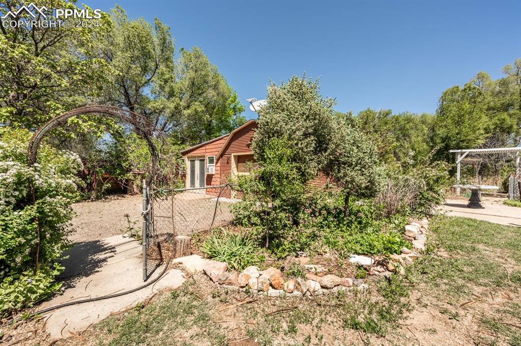 2233 Daniel Road Pueblo, CO 81006 - Photo 25 of 48 a backyard of a house with table and chairs under an umbrella