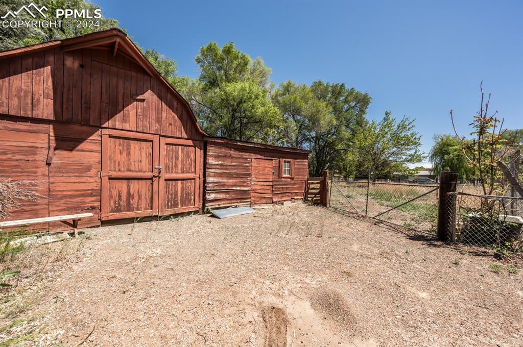 2233 Daniel Road Pueblo, CO 81006 - Photo 43 of 48 a backyard of a house with wooden fence and large trees