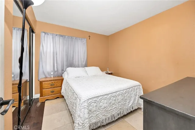 a bedroom with a bed and a dresser with wooden floor