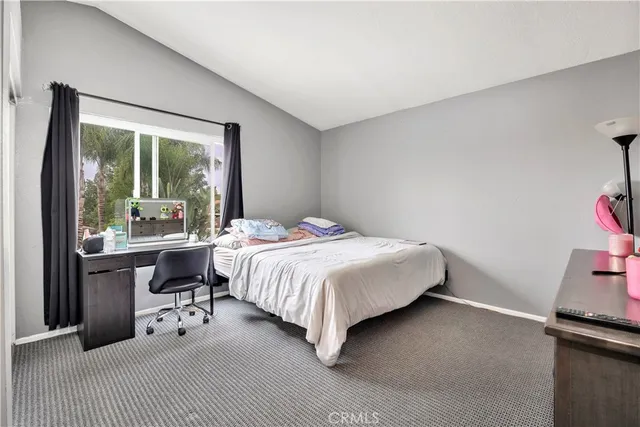 a bedroom with a bed and large windows