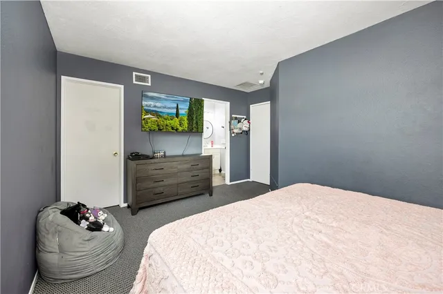 a bedroom with a bed and flat screen tv