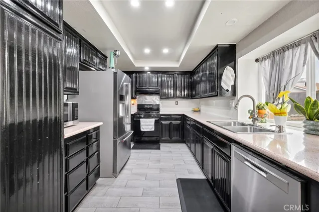 a kitchen with stainless steel appliances granite countertop sink refrigerator and microwave