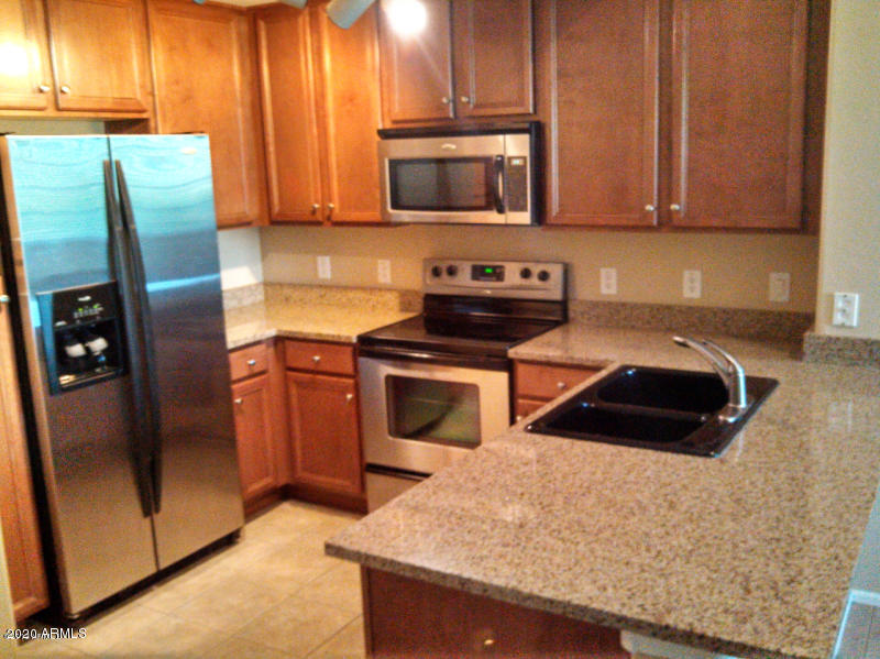 4081 East Windsor Drive Gilbert, AZ 85296 - Photo 2 of 8 a kitchen with granite countertop a refrigerator stove and microwave