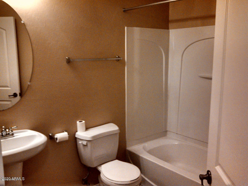 4081 East Windsor Drive Gilbert, AZ 85296 - Photo 7 of 8 a white toilet sitting next to a bathroom sink and tub