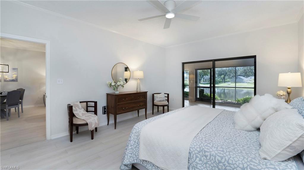 606 Arbor Lake Drive, Unit 6104 Naples, FL 34110 - Photo 12 of 36 a bedroom with a bed a mirror and a table