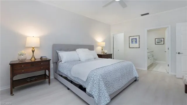 a bedroom with a bed and a lamp on dresser