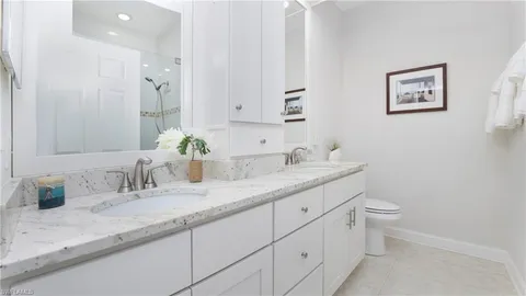 a bathroom with a granite countertop sink mirror and toilet
