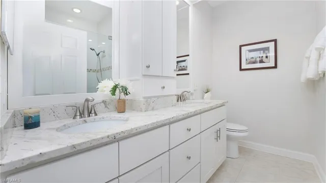 a bathroom with a granite countertop sink mirror and toilet