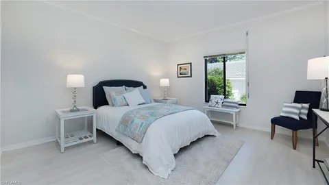 a bedroom with a bed chair and a window