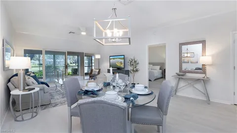 a living room with furniture a chandelier and a dining table