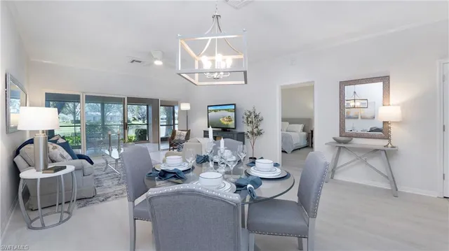 a living room with furniture a chandelier and a dining table