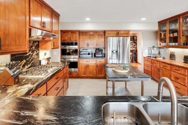 a kitchen with sink refrigerator and microwave
