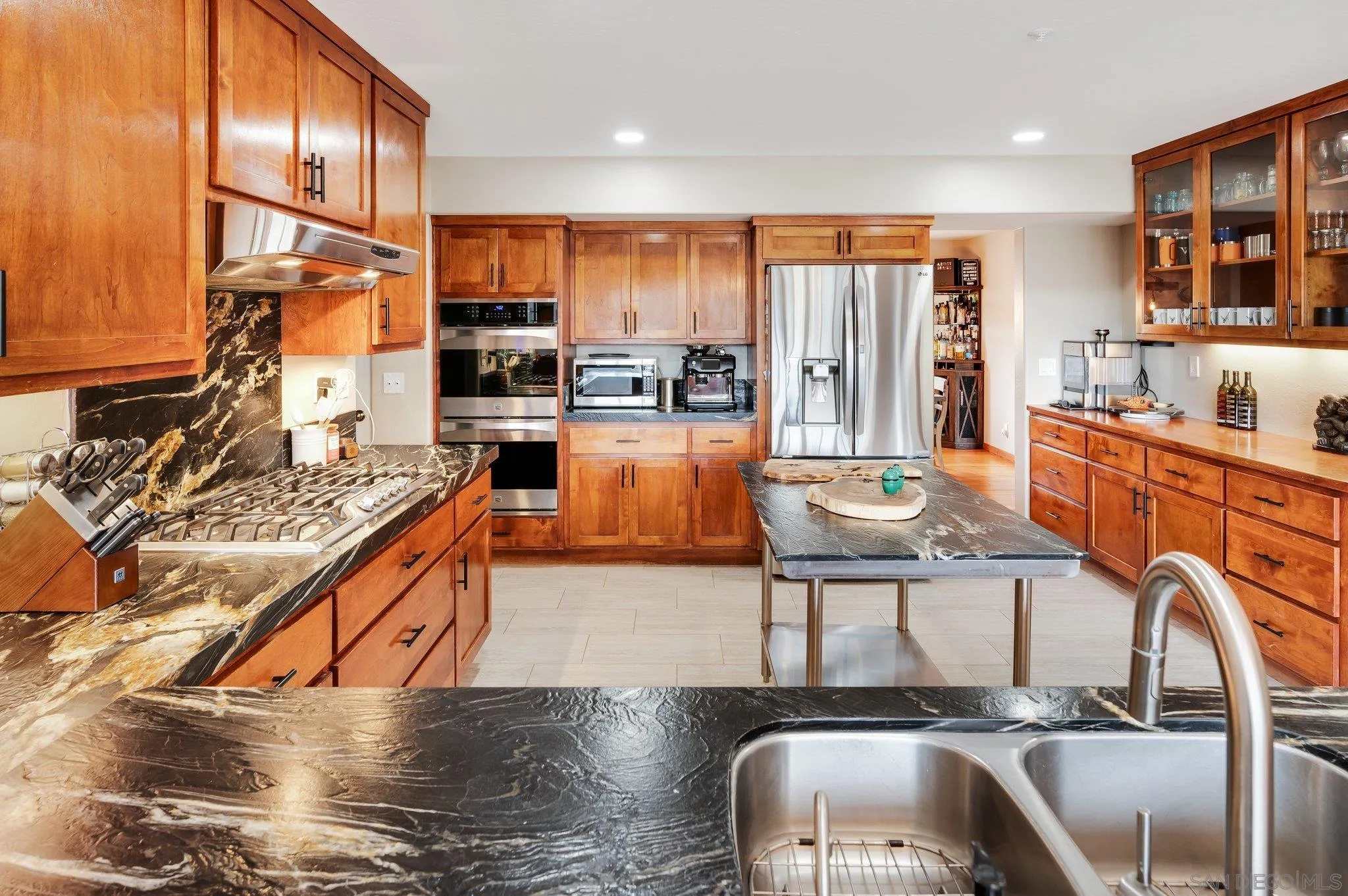 17287 Oak Hollow Road Ramona, CA 92065 - Photo 11 of 71 a kitchen with stainless steel appliances granite countertop a stove top oven a sink dishwasher and cabinets with wooden floor