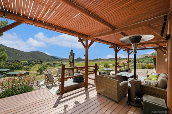 a view of a balcony with dining table and chairs with wooden floor and fence