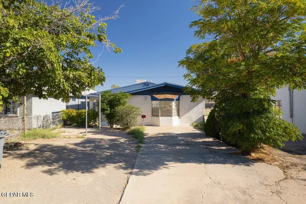 a front view of a house with a yard and trees