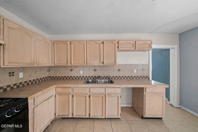 a kitchen with white cabinets and sink
