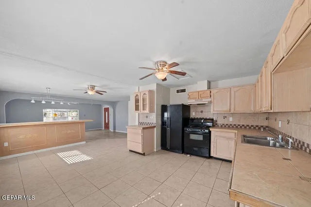 a kitchen with stainless steel appliances granite countertop a refrigerator and a stove top oven