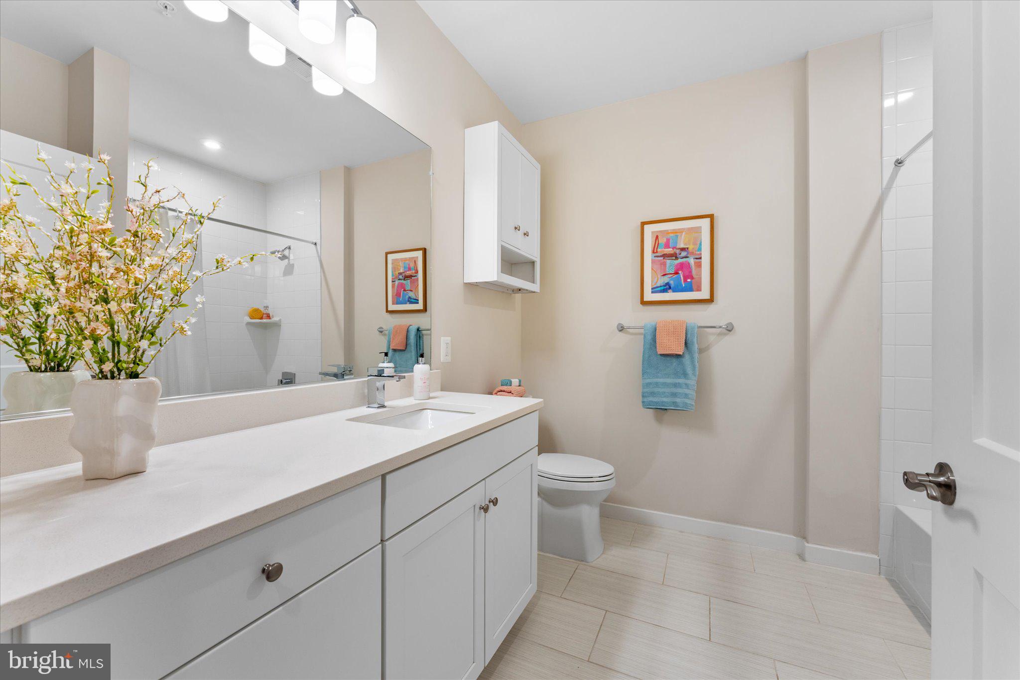 1669 Bandit Loop, Unit 206A Reston, VA 20190 - Photo 14 of 60 a bathroom with a granite countertop sink a toilet and a mirror
