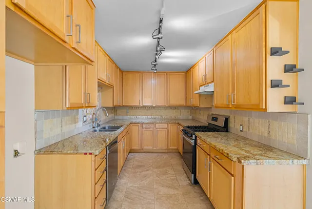 a kitchen with a sink stove and cabinets