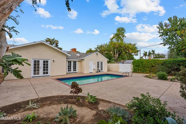 a view of front of house with a yard and potted plants