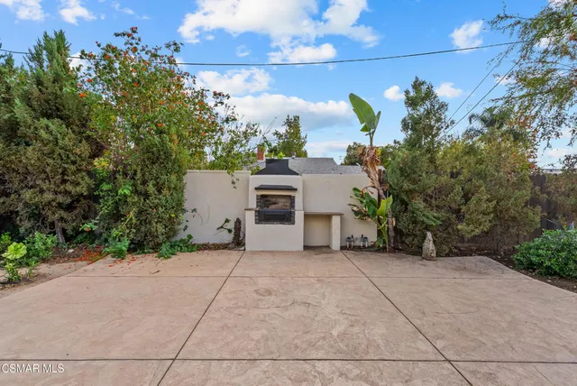 front view of a house with a yard and potted plants