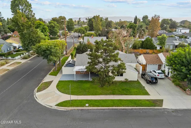 an aerial view of a house with swimming pool and trees