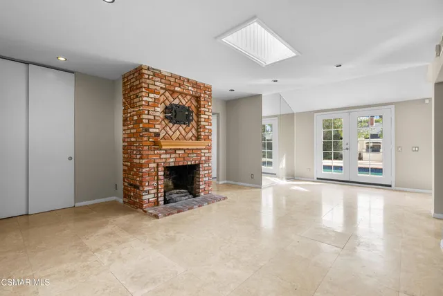 a view of an empty room with a fireplace and a window